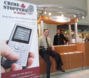 Det. Sgt Keith Nakahara, at the Crime Stoppers booth at Burlington Mall last weekend explains how to protect yourself from identity theft.  Robert Strutt of Shred-It is in the background.