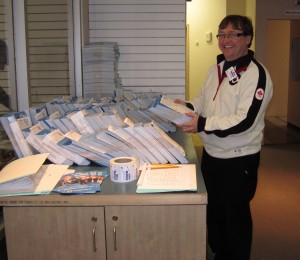 Mike Wallace looking over the piles of literature that will get dropped off at every door in the riding.