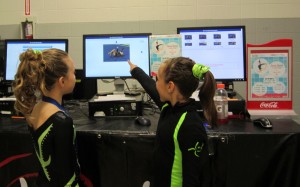 Gymnastic girls looking at pictures Every move made on either the floor work, bars or vaults was photographed and available to the participants. Two gymnasts look at a performance deciding if they want the picture.
