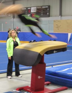 Kathy Kline, a parent who was once a gymnast keeps a close eye on a gymnast doing vault work.