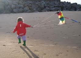 Kite flying - kid with kite Getting that kite up into the air is the first challenge – then the fun starts keeping it in the air.