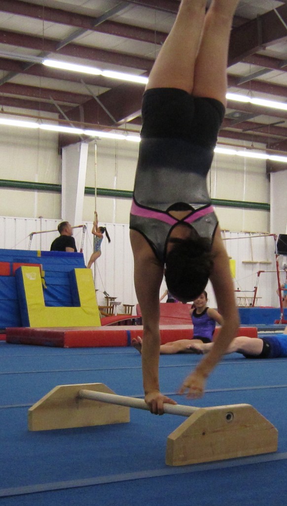 Gymnastics - begin twirl Now the actual twirl. Having grasped the bar the athlete then releases one hand and begins to place left hand over right hand and in the process twirling her body – all the while keeping her legs straight up into the air. Getting to the point where they mount the bar, do the twirl and then dismount takes hours and hours of hard work.