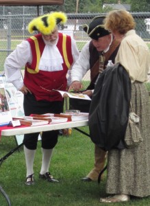 Dave Vollick, his wife and a War of 1812 re-enactor look over some material.  Vollick was acclaimed as Burlington’s Town Crier for the next four years.