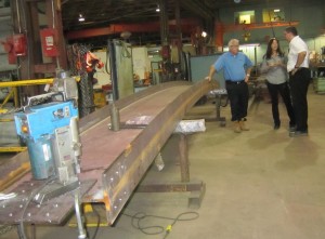 General Manager Scott Stewart with Deb Franke of AJ Braun and Craig Stevens discuss the welding of beams for the Pier. The progress schedule is top of mind for all three. One of the beams being welded is shown.