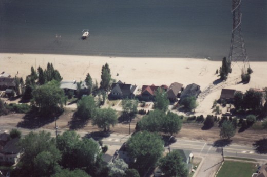 Aerial of Strip 1990. brown dirt in foreground beside Lakeshore Rd. where Terry cottages used to be- cottages were double stacked, only cottages along beach remain in 1990.
