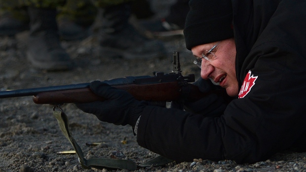 Harper firing a rifle