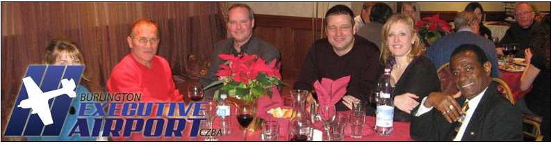 Lisa Raitt, second from the right, Tim Crawford centre behind the flowers and Vince Rossi in the red sweater. The flowers suggest a Christmas event.