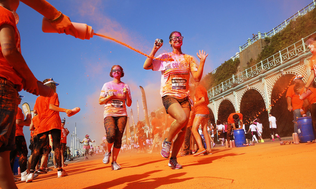 Competitors are showered with colour powders as they participate in the Color Run in Brighton, southern England September 20, 2014. Inspired by the Hindu Holi festival, participants take part in a five kilometre run dotted with locations where coloured powders are thrown over the runners.  REUTERS/Luke MacGregor  (BRITAIN - Tags: ENTERTAINMENT SOCIETY SPORT)
