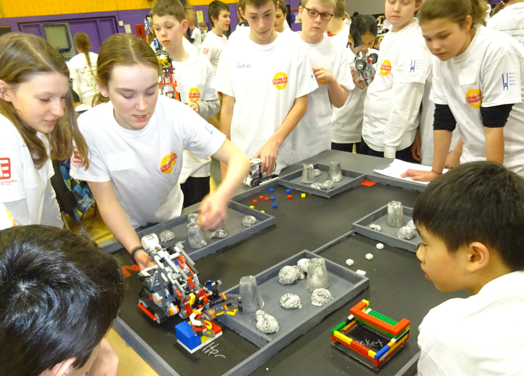 Pre teens with robots on table