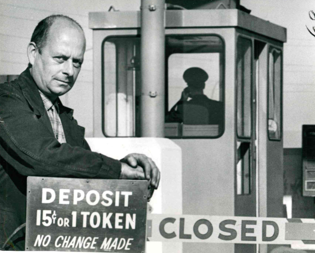 A city worker, Robert Collins carries away one of the automatic toll-takers.  The electric devices were removed from the Burlington Skyway because motorist tossing coins were too often off the target. toll booth Burlington Skyway September 30, 1964 Hamilton historical collection