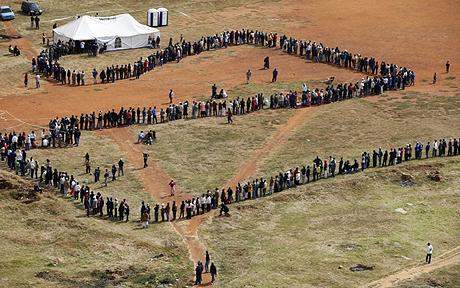 People queue to cast their votes at a polling station in the Katlehong township, east of Johannesburg, South Africa, Wednesday, April 22, 2009. Voters lined up before sunrise Wednesday in an election that has generated an excitement not seen since South Africa's first multiracial vote in 1994, and that was expected to propel Jacob Zuma to the presidency after he survived corruption and sex scandals. (AP Photo/Denis Farrell)